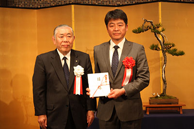 管材料贈呈式(全設研の川崎事務長(右))